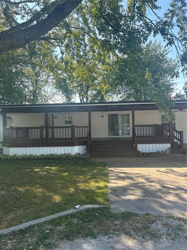 view of front facade with a wooden deck and a front lawn