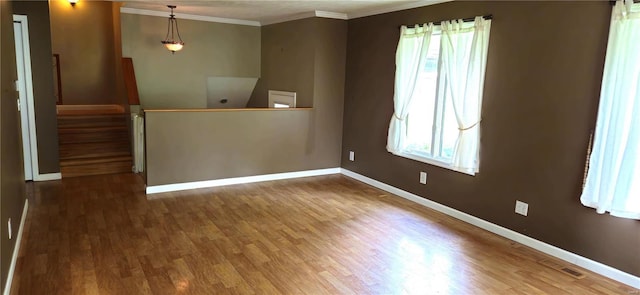 unfurnished room with wood-type flooring and crown molding