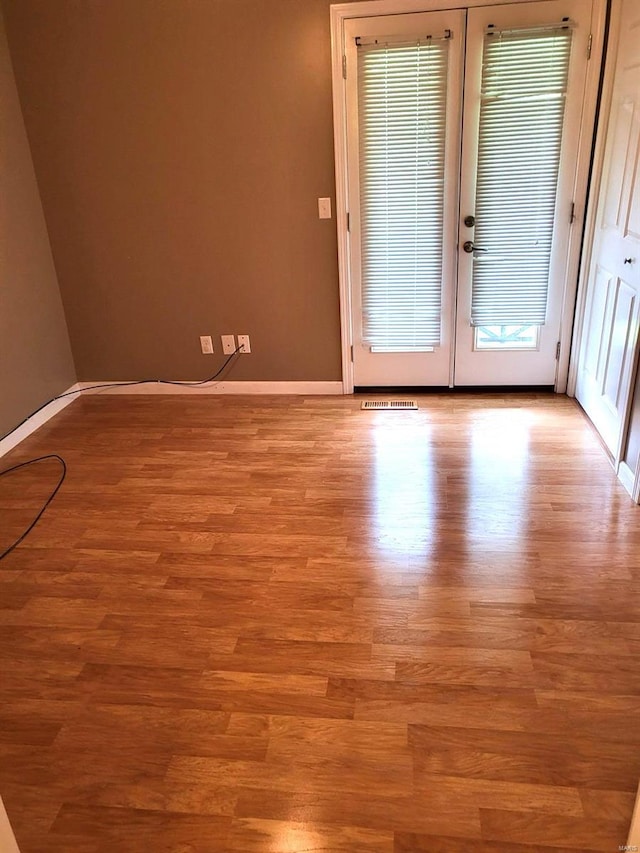 unfurnished room with light wood-type flooring and french doors