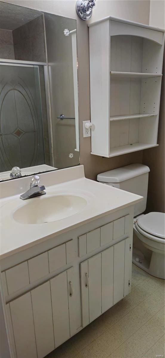 bathroom with vanity, toilet, and walk in shower