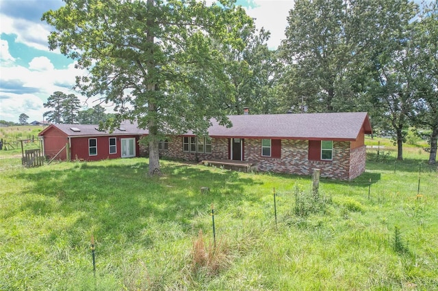 ranch-style house featuring a front lawn, fence, and brick siding