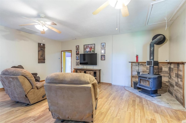 living area with attic access, ceiling fan, and wood finished floors