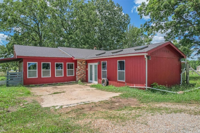 view of front of property with a patio, french doors, and fence