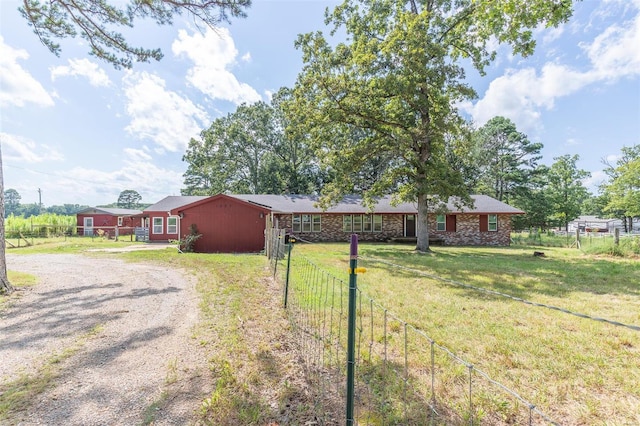 single story home with driveway, a front yard, and fence