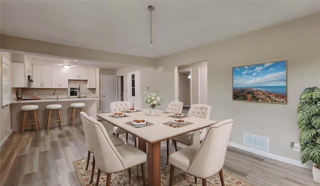 dining space featuring sink and light hardwood / wood-style flooring