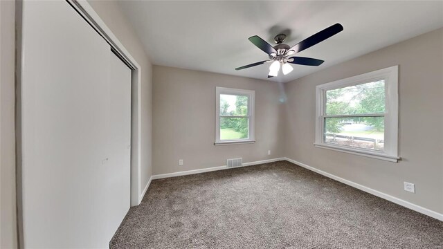 unfurnished bedroom featuring carpet flooring, ceiling fan, and a closet