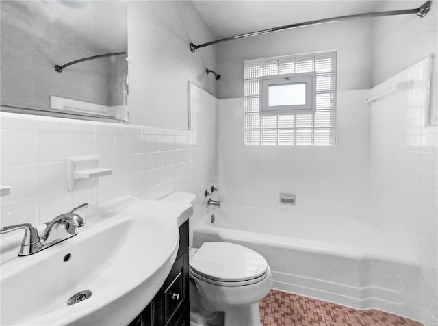 full bathroom with vanity, tiled shower / bath, tile walls, and toilet