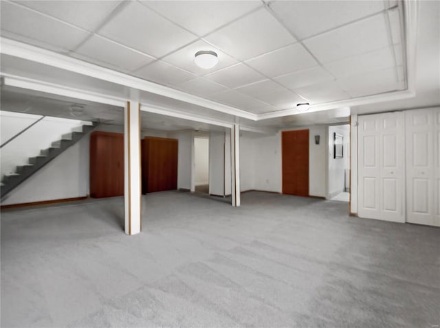 basement with carpet flooring and a paneled ceiling