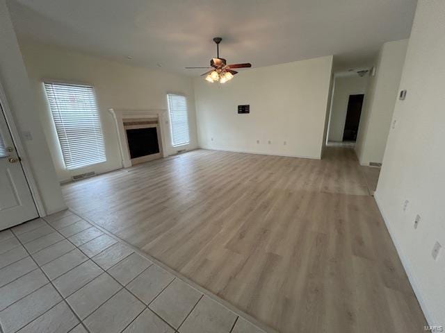 unfurnished living room featuring ceiling fan and light tile patterned floors