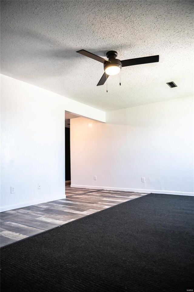 unfurnished room featuring carpet, ceiling fan, and a textured ceiling