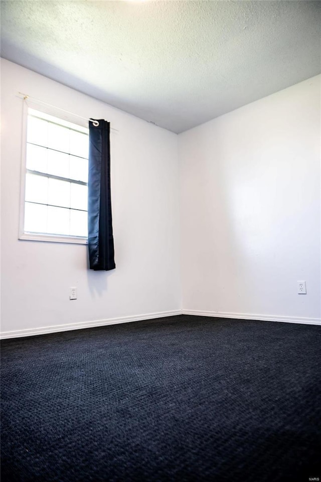 unfurnished room with a textured ceiling and carpet flooring