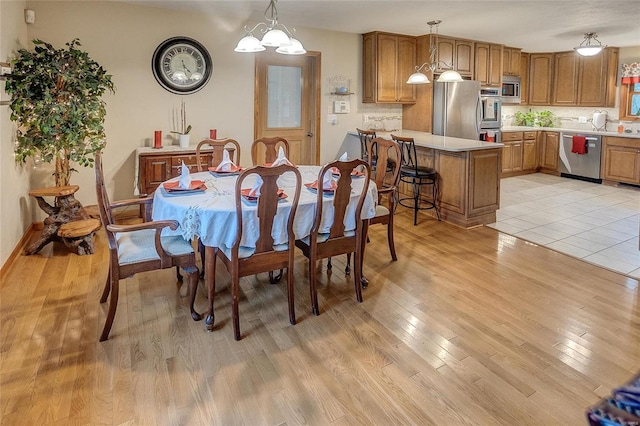 dining room featuring light wood-type flooring and a chandelier