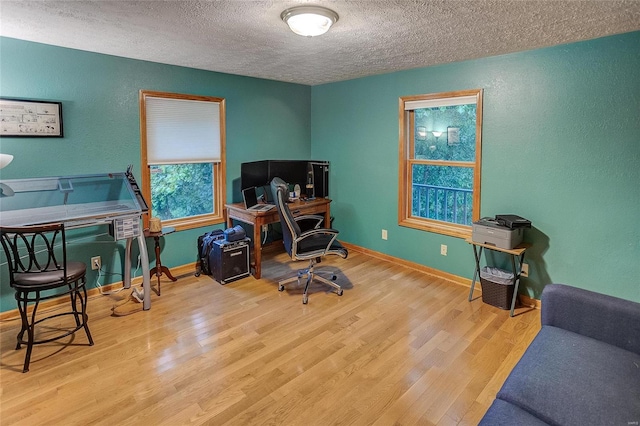 office area featuring a textured ceiling and light wood-type flooring