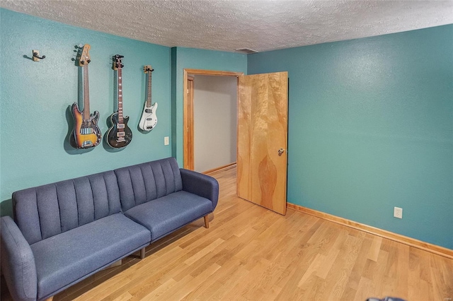 sitting room featuring light hardwood / wood-style flooring and a textured ceiling