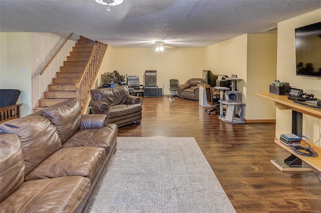 living room with ceiling fan, dark wood-type flooring, and a textured ceiling