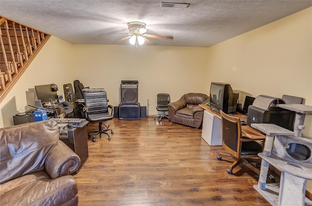 home office with ceiling fan, a textured ceiling, and hardwood / wood-style floors