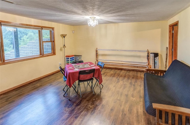 dining space featuring hardwood / wood-style floors, a textured ceiling, and an inviting chandelier