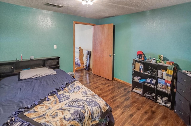 bedroom with dark wood-type flooring and a textured ceiling