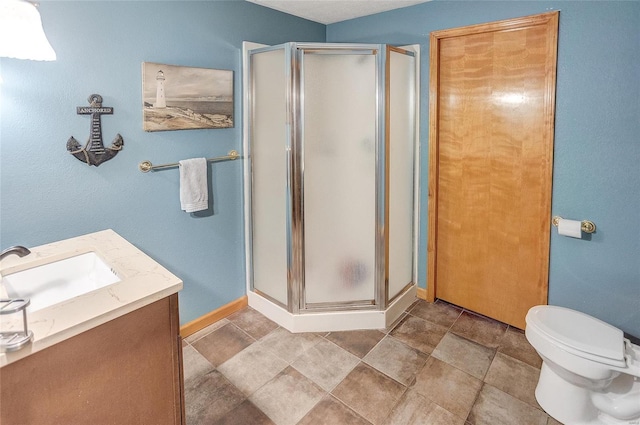 bathroom featuring tile patterned floors, vanity, toilet, and a shower with shower door