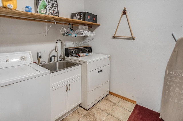 washroom featuring cabinets, washing machine and dryer, light tile patterned floors, and sink