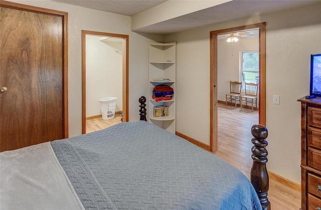 bedroom with light wood-type flooring and ensuite bath