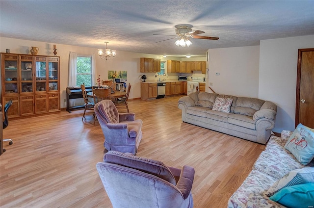 living room with ceiling fan with notable chandelier, a textured ceiling, and light wood-type flooring