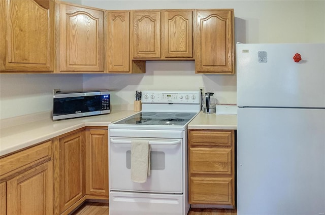 kitchen featuring light hardwood / wood-style flooring and white appliances