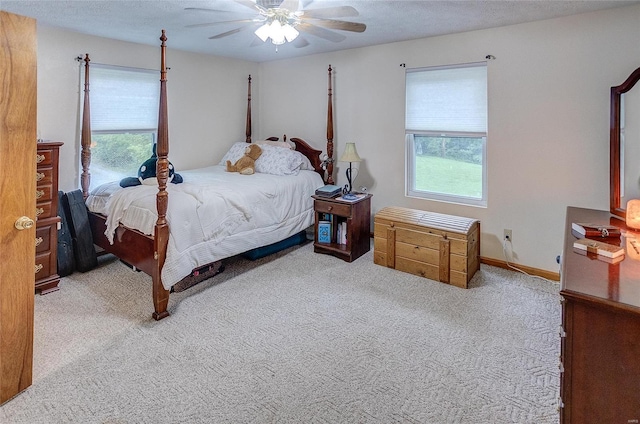 bedroom featuring ceiling fan, multiple windows, and light colored carpet