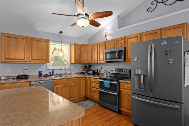 kitchen featuring appliances with stainless steel finishes, lofted ceiling, sink, ceiling fan, and light hardwood / wood-style floors