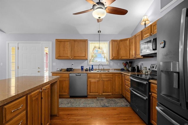 kitchen with sink, stone countertops, decorative light fixtures, dark hardwood / wood-style floors, and stainless steel appliances