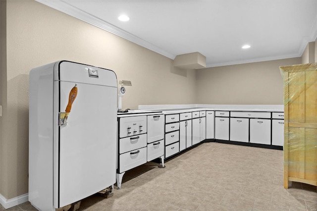 kitchen with white cabinetry, fridge, crown molding, and a mail area