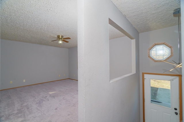 interior space with plenty of natural light, ceiling fan, a textured ceiling, and light carpet