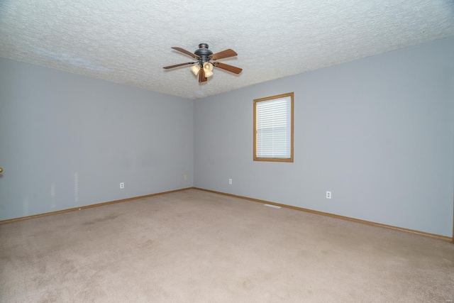 spare room featuring ceiling fan, carpet floors, and a textured ceiling