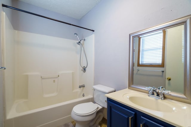 full bathroom featuring vanity, toilet, a textured ceiling, and shower / washtub combination