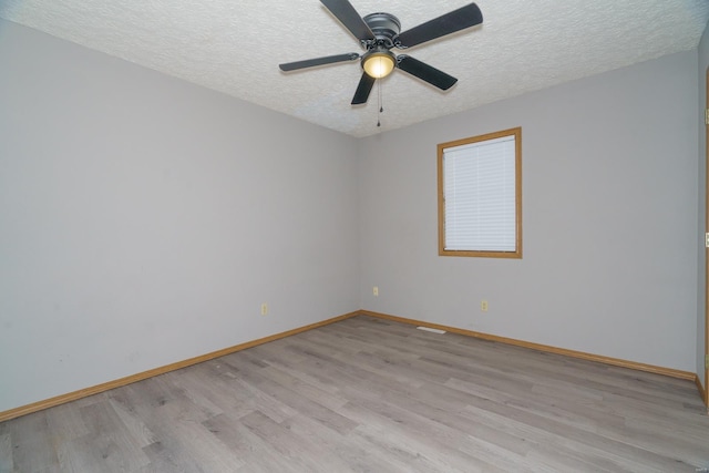 empty room with ceiling fan, light hardwood / wood-style flooring, and a textured ceiling