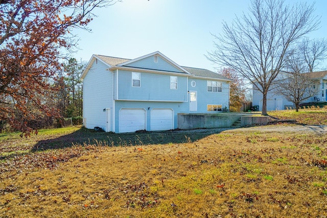 back of house with a yard and a garage