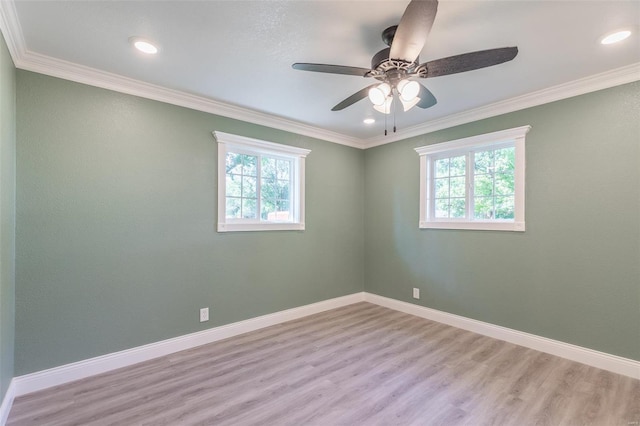 spare room featuring ornamental molding, light hardwood / wood-style floors, and a wealth of natural light