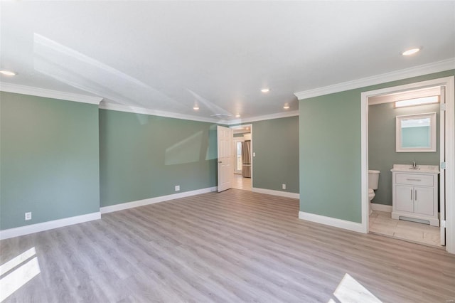 unfurnished bedroom featuring crown molding, sink, connected bathroom, and light wood-type flooring