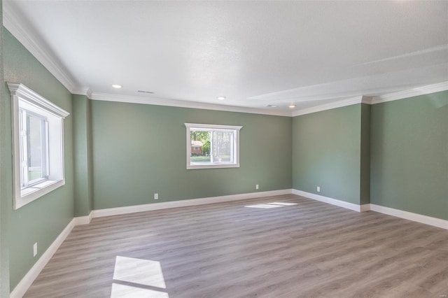 empty room featuring ornamental molding and light hardwood / wood-style flooring