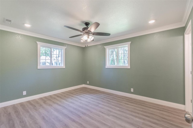 unfurnished room with ornamental molding, a wealth of natural light, and light hardwood / wood-style flooring