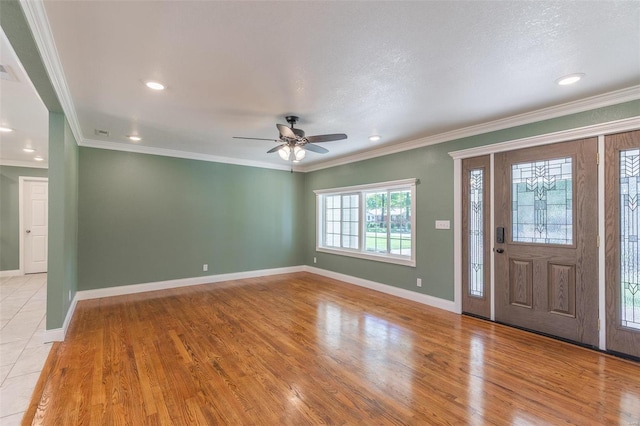 entryway featuring a textured ceiling, light hardwood / wood-style flooring, ornamental molding, and ceiling fan