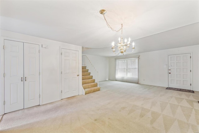 unfurnished living room with light carpet and a notable chandelier