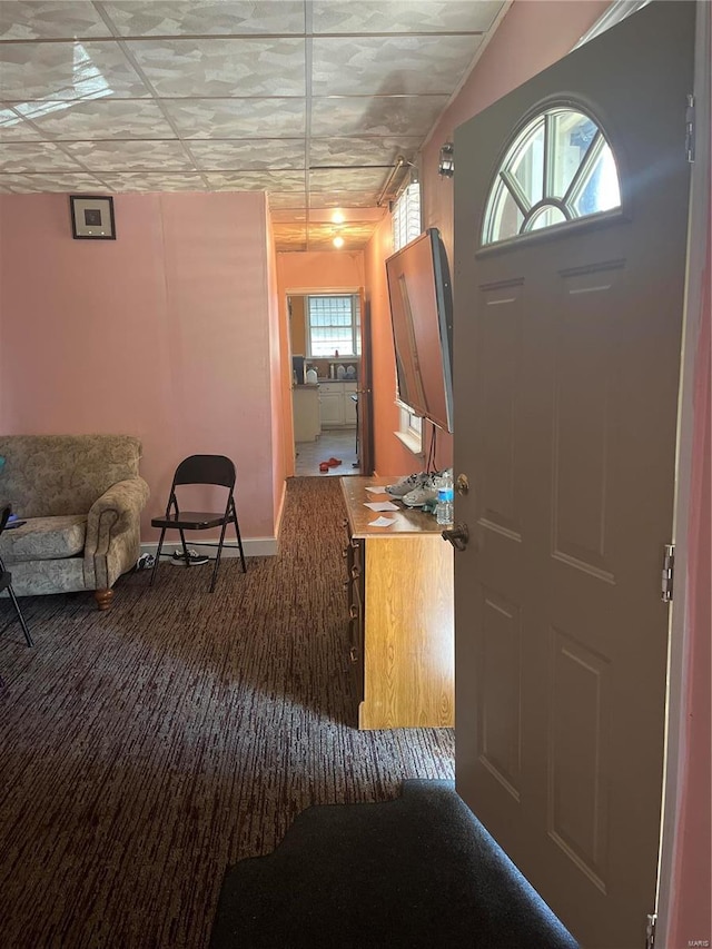 entrance foyer with plenty of natural light and dark colored carpet