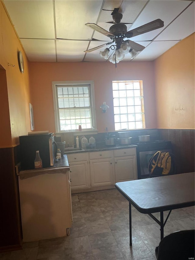 kitchen featuring backsplash, ceiling fan, white cabinets, and tile patterned floors