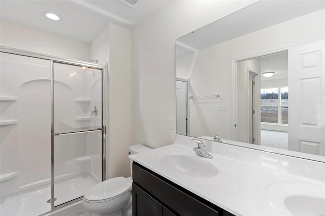 bathroom with vanity, a shower with shower door, and toilet