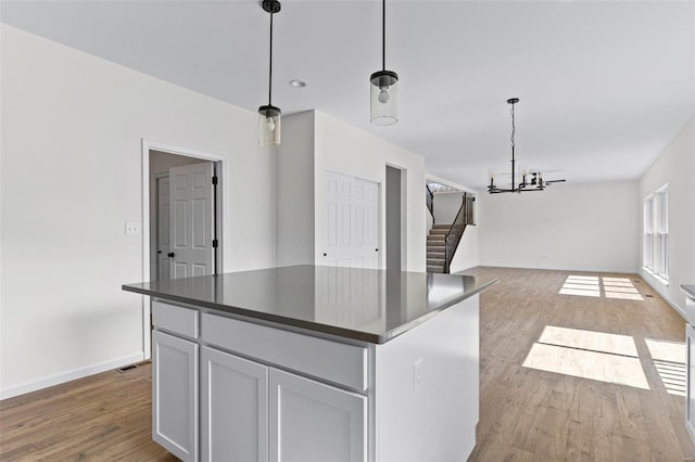 kitchen with dark countertops, open floor plan, wood finished floors, and a center island