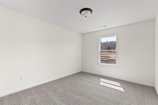 unfurnished room with carpet floors, visible vents, and baseboards