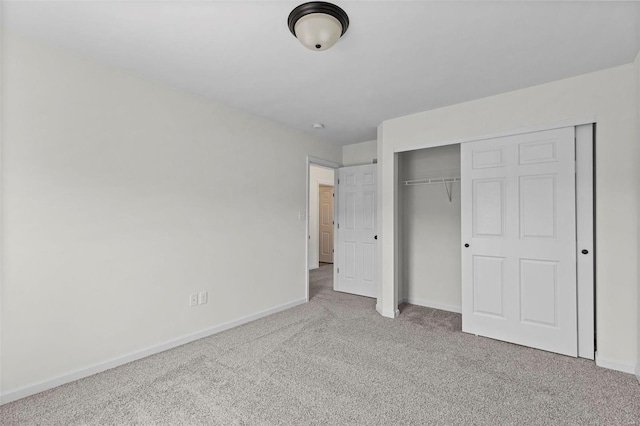 unfurnished bedroom featuring carpet floors, a closet, and baseboards