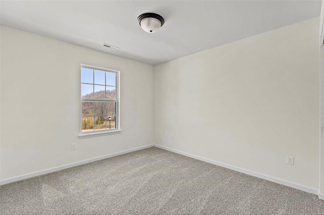 carpeted spare room featuring visible vents and baseboards