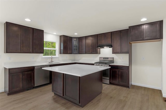 kitchen featuring sink, a kitchen island, light hardwood / wood-style floors, dark brown cabinetry, and stainless steel appliances